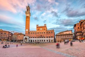 a city with a clock tower and a building at Grazioso Appartamento a 500m da Piazza del Campo - ZTL Free in Siena