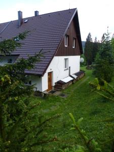 une grande maison blanche avec un toit noir dans l'établissement Ubytování Lyžařská škola, à Kubova Huť