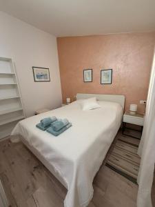 Un dormitorio con una cama blanca con toallas. en Apartman Etta - Šišan, en Šišan