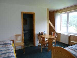 クボヴァ・フチにあるUbytování Lyžařská školaのベッド、テーブル、椅子が備わる客室です。