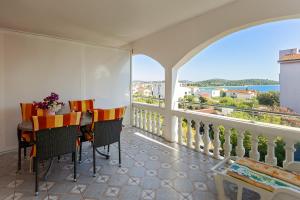 a balcony with a table and chairs and a view of the ocean at Spacious Terrace Apartments in Rogoznica