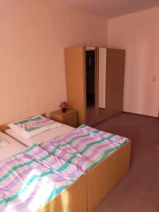 a bedroom with a bed with a striped comforter at müstakil ev in Hainburg