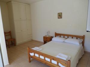 a bedroom with a large bed and a chair at Rosa's Studios in Fiskardo