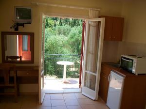 a kitchen with a door open to a patio at Rosa's Studios in Fiskardo