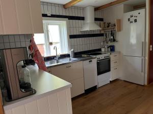 a kitchen with white appliances and a white refrigerator at Skräddarhuset - Lilla huset in Bonnarp
