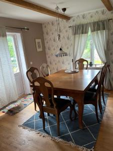 a dining room with a wooden table and chairs at Skräddarhuset - Lilla huset in Bonnarp +5 photos