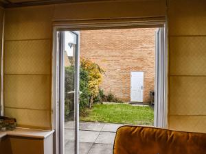 a sliding glass door leading to a yard at Coopers Townhouse - Cottage in Worle