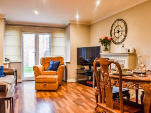 a living room with a tv and a table and chairs at Coopers Townhouse - Cottage in Worle