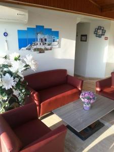 a living room with a couch and a table and flowers at Yona Motel in Çeşme