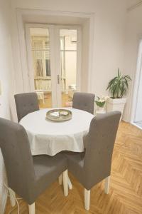 贝尔格莱德ELEGANT STAY-Boutique Apartment Experience的一间有白色桌子和椅子的餐厅