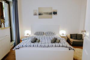 a bedroom with a large white bed with two pillows at Casa Santini in Jáchymov