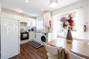 a kitchen with a table and a vase with flowers on it at Manchester Serenity House in Manchester