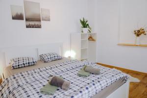 a white bedroom with a bed with two pillows at Casa Santini in Jáchymov +51 photos