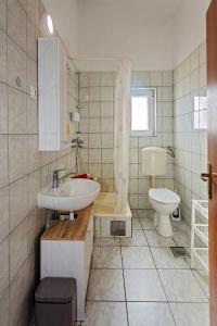 a bathroom with a sink and a toilet at Spacious Terrace Apartments in Rogoznica +17 photos