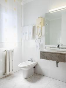 a white bathroom with a sink and a toilet at Hotel Stellamaris in Combarro +33 photos