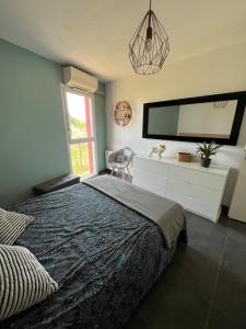 a bedroom with a bed and a large tv on the wall at Appartement ds résidence avec piscine Mauguio Carnon in Mauguio