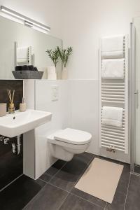a white bathroom with a toilet and a sink at glorious cloud apartment in Berlin
