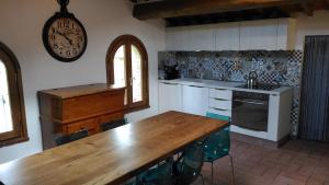 a kitchen with a wooden table and a clock on the wall at Capanna 1826 in San Gimignano