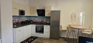 a kitchen with white cabinets and a table with chairs at Apartment Emma&Lea in Neusiedl am See