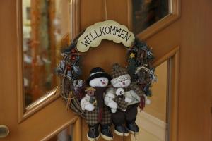 a christmas wreath with snowmen on a door at Alpin Apartments Colfosco in Colfosco