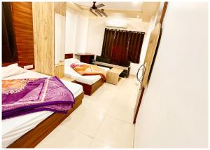 乌贾因Near Mahakal Temple Hotel SRI- D K D ! Ujjain,Near Railway station, Fully Air conditioned Rooms & Spacious Room With wifi- Lift and Restaurant Facilities, BEST HOTEL IN UJJAIN的有两张床和一扇窗户的卧室