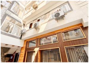 乌贾因Near Mahakal Temple Hotel SRI- D K D ! Ujjain,Near Railway station, Fully Air conditioned Rooms & Spacious Room With wifi- Lift and Restaurant Facilities, BEST HOTEL IN UJJAIN的一座带窗户和木门的建筑