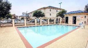 a large blue swimming pool in front of a building at Quality Inn & Suites Airport in Austin