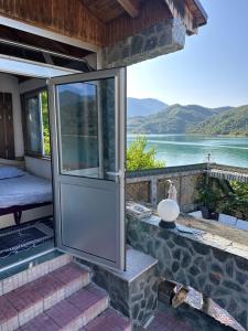 a glass door on a house with a view of a lake at Vikendica Plavi Mir in Konjic