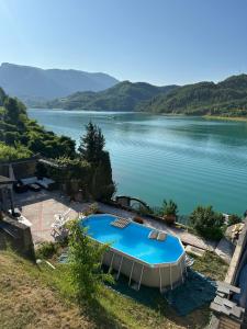 a swimming pool with a view of a lake at Vikendica Plavi Mir in Konjic