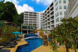 a swimming pool with lounge chairs and a building at C134 Condo 1BR in Heart of Patong Pool, Beach, Bangla in Patong Beach