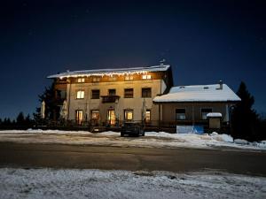 a large building with lights on it in the snow at Chalet Monte Coston in Lastebasse