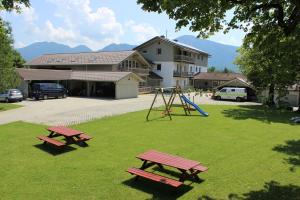 2 Picknicktische und ein Spielplatz im Park in der Unterkunft Haus Sonnbichel am Kochelsee in Schlehdorf