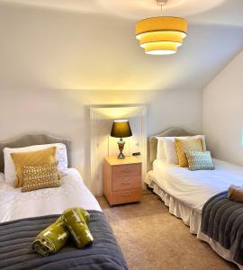 a bedroom with two beds and a lamp on a night stand at 1800's Cosy Cottage in Dungarvan in Balnacart