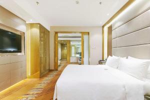 Postel nebo postele na pokoji v ubytování Suning Universal Hotel ALL-SUITES