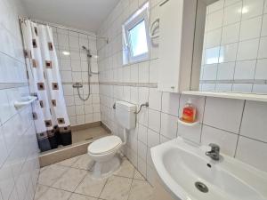 a white bathroom with a toilet and a sink at Cozy Apartments Baška in Baška +92 photos