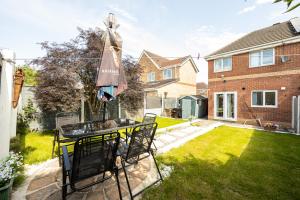 a patio with a table and chairs in a yard at Manchester Serenity House in Manchester