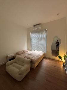 una camera da letto con un letto, una sedia e una finestra di June Homestay a Hue