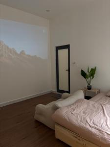 una camera da letto con un letto e uno specchio sul muro di June Homestay a Hue Altre 2 foto