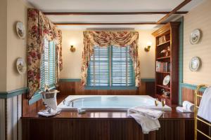 baño con bañera y ventana en Captain's House Inn en Chatham