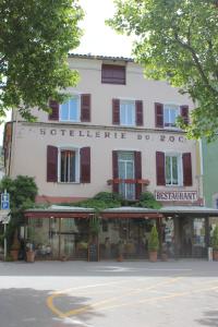 - un grand bâtiment blanc avec un panneau dans l'établissement Hôtel du Roc, à Castellane