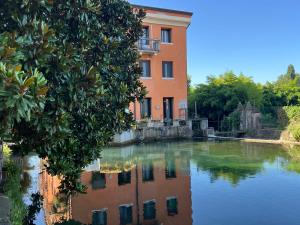 een gebouw naast een waterlichaam bij La casa ai Laghetti in Montorio Veronese