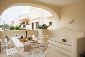 a room with a table and chairs and a balcony at Antica Via Roma B&B E RELAX in Montalbano
