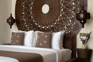 a bedroom with a bed with a large wooden headboard at Sunny Samudra Boutique hotel Uluwatu in Uluwatu