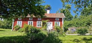 een rood huis in het midden van een veld bij Lillåns B&B in Örebro