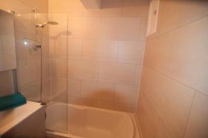 une salle de bain avec une douche avec une porte vitrée dans l'établissement Duinenblik 3, à Nieuport 11 autres photos