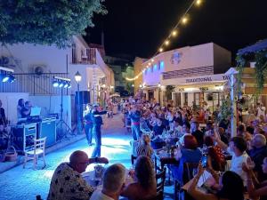 a crowd of people watching a man on a stage on a street at Kapsalia Holiday Villas in Pissouri +66 photos