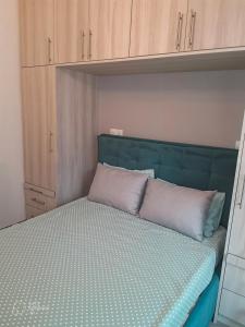 a bed with a green headboard in a bedroom at Melodia Lefkada Apartment 3 in Nikiana +8 photos