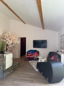 Saint-Vincent-de-PaulにあるMaison M Intime Roomのベッドとテレビのあるリビングルーム