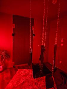 Saint-Vincent-de-PaulにあるMaison M Intime Roomのブランコが2つある赤い部屋 +9枚の写真