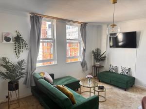 a living room with two green couches and a table at Serene Ocean Side Apartment BTN in Brighton & Hove
